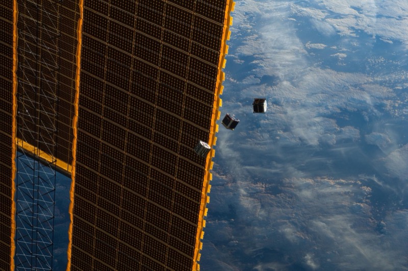 CubeSats deploying from the International Space Station with Earth in background